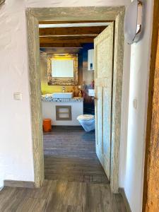 an open doorway to a bathroom with a sink and a toilet at Maisonette Eifel, mit Sauna und Whirlpool in Dahlem