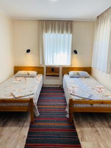 een kamer met 2 bedden en een raam bij Vila Roz in Trebujeni