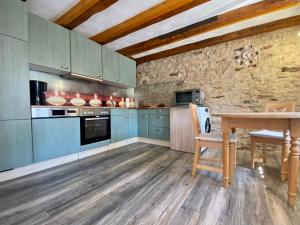 a kitchen with blue cabinets and a wooden table at Maisonette Eifel, mit Sauna und Whirlpool in Dahlem