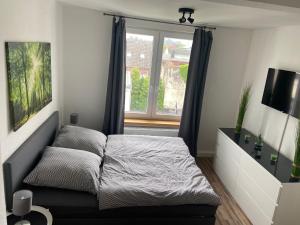 a small bedroom with a bed and a window at Ferienwohnung Robbe in Wilhelmshaven