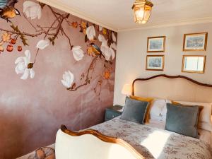 um quarto com uma cama com flores na parede em The beach cottage em Folkestone