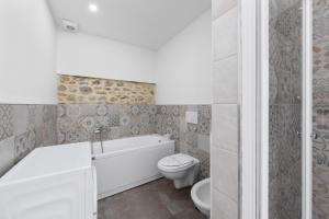 La salle de bains est pourvue d'une baignoire, de toilettes et d'un lavabo. dans l'établissement Teatro della Pergola Apartment, à Florence