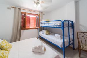 Cette chambre comprend 2 lits superposés et une table. dans l'établissement Expoholidays-Chalet Bahari primera linea de playa, à Roquetas de Mar