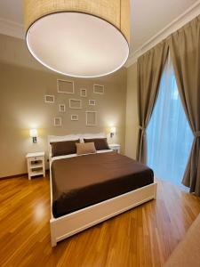 AviglianoにあるL’Arco Bed&Breakfastのベッドルーム1室(大型ベッド1台、大きなシャンデリア付)