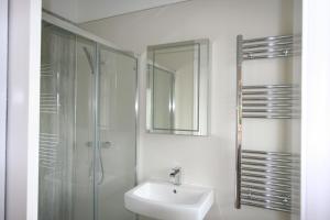 a white bathroom with a sink and a shower at Crossing Cottage Sleeps 6 Parking, Family & Contractors Newark in Staythorpe