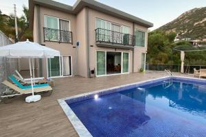 a villa with a swimming pool and a house at LA VILLA CELINE- XLarge villa complete privacy in nature, pool with wondeful view in Kalkan