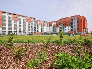 a row of apartment buildings in a field with plants at Holiday Suites Zeebrugge in Zeebrugge