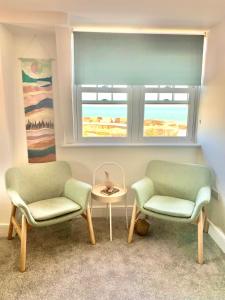 2 sillas y una mesa en una habitación con ventana en SkyView Eastbourne 24, en Eastbourne