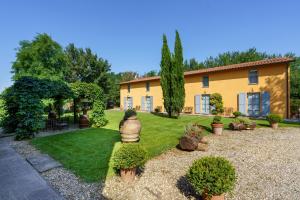 a house with a yard with plants and trees at La Scuderia Casa Vacanze in San Zeno