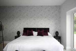a bedroom with a large white bed with red pillows at Crossing Cottage Sleeps 6 Parking, Family & Contractors Newark in Staythorpe