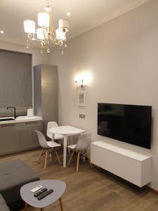 a living room with a large television and a table at MARBEO 5 Star Luxury Suites - Peldu in Liepāja