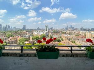 a view of a city from a balcony with red flowers at Pass the Keys Spacious 2Bedroom flat with views in London Bridge in London