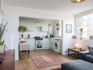 a kitchen with blue cabinets and a living room at Pass the Keys Spacious 2Bedroom flat with views in London Bridge in London