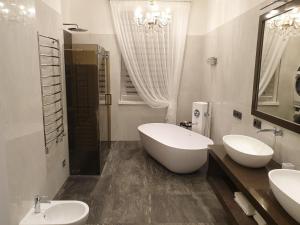 a bathroom with two sinks and a tub at MARBEO 5 Star Luxury Suites - Peldu in Liepāja