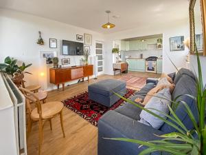 a living room with a blue couch and a kitchen at Pass the Keys Spacious 2Bedroom flat with views in London Bridge in London