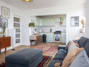 a living room with a blue couch and a kitchen at Pass the Keys Spacious 2Bedroom flat with views in London Bridge in London