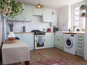 a kitchen with white cabinets and a washing machine at Pass the Keys Spacious 2Bedroom flat with views in London Bridge in London