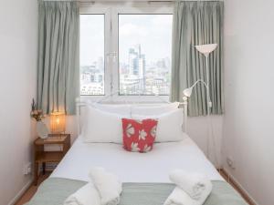 a bedroom with a white bed with a large window at Pass the Keys Spacious 2Bedroom flat with views in London Bridge in London