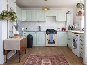 a kitchen with white cabinets and a table with a rug at Pass the Keys Spacious 2Bedroom flat with views in London Bridge in London