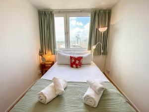 a bed with towels on it with a window at Pass the Keys Spacious 2Bedroom flat with views in London Bridge in London