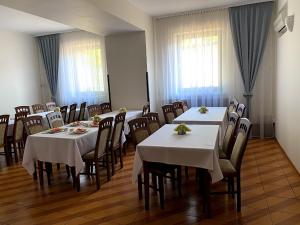 a dining room with tables and chairs with white tablecloths at Obiekt "Czarny Rycerz" in Jastrzębie Zdrój