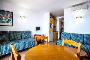 salon z 2 niebieskimi kanapami i stołem w obiekcie Hotel Apartamentos Mojácar Beach w mieście Mojácar