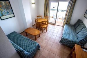 una sala de estar con 2 sofás azules y una mesa. en Hotel Apartamentos Mojácar Beach, en Mojácar