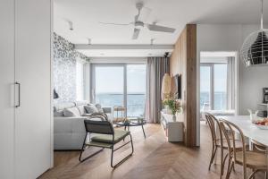a living room with a couch and a table with chairs at Apartamenty Balticus SeaView by Rent like home in Międzyzdroje