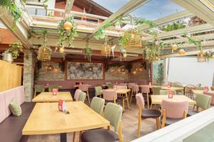 a restaurant with wooden tables and chairs and plants at Hotel San Marco in Füssen