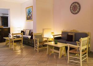 sala de estar con sofá, mesas y reloj en Elpida Village, en Istron