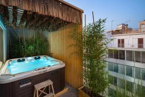 a bathroom with a tub on a balcony at Athens Warehouse Boutique Hotel & Suites in Athens