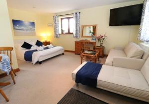ein Wohnzimmer mit 2 Betten und einem Sofa in der Unterkunft The Studio with Terrace Kelly Bray Cornwall in the Tamar Valley in Callington