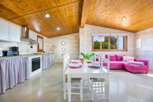 kuchnia i salon ze stołem i różową kanapą w obiekcie Biniaco w mieście Muro