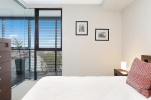 a bedroom with a white bed and a large window at Stylish 1 bdrm Camperdown - Car park, Gym & Pool in Sydney +21 photos