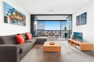 a living room with a couch and a table at Stylish 1 bdrm Camperdown - Car park, Gym & Pool in Sydney