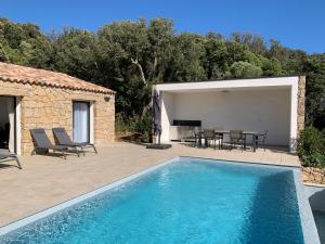 a swimming pool in front of a house with a patio at DOMAINE NAPOLEON CORSICA FIGARI in Figari