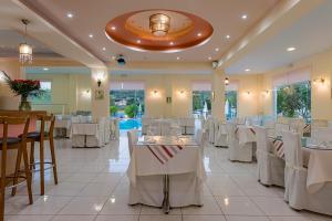 a banquet hall with white tables and chairs at Dinos Hotel in Tsilivi