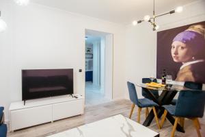 - un salon avec une télévision et une table avec des chaises dans l'établissement Apartman Stella Maris, à Ljubuški