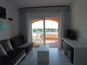 salon z kanapą i widokiem na patio w obiekcie Arenas de Son Bou w Son Bou