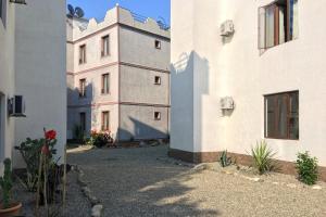 an alley between two white buildings with flowers at Aparthotel Sofia in Gonio in Gonio