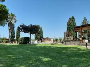 un parc avec de l'herbe verte et un pavillon dans l'établissement Il Giardino dei Pini, à Paestum