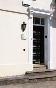 a white house with a black door at Modern apartment in Leamington Spa City Centre in Leamington Spa