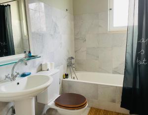 a bathroom with a sink and a toilet and a bath tub at Rex Hotel - Bebeka's in Zakharo