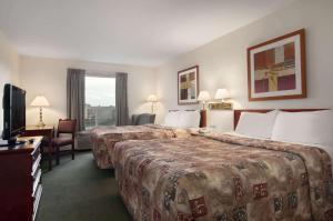 um quarto de hotel com duas camas e uma televisão em Travelodge by Wyndham Stony Plain em Stony Plain
