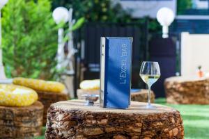 a book and a glass of wine on a tree stump at Nice Excelsior Centre ville by HappyCulture in Nice