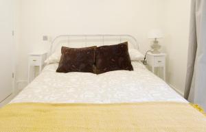 uma cama branca com duas almofadas em cima em Modern apartment in Leamington Spa City Centre em Leamington Spa
