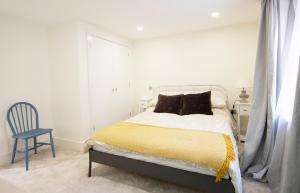 a white bedroom with a bed and a blue chair at Modern apartment in Leamington Spa City Centre in Leamington Spa