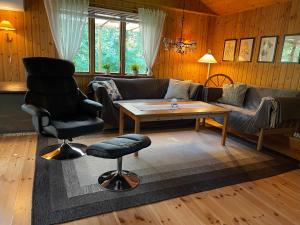 a living room with a couch and a table and a chair at Fyrvägen 13 'Ydermossa' NEW! in Munka-Ljungby
