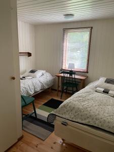 1 dormitorio con 2 camas, mesa y ventana en Fyrvägen 13 'Ydermossa' NEW!, en Munka-Ljungby