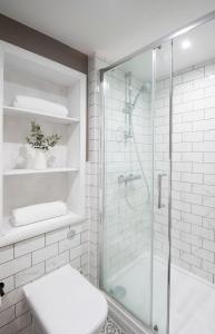 a white bathroom with a shower and a toilet at Modern apartment in Leamington Spa City Centre in Leamington Spa